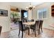 Bright dining area includes a table with six leather chairs and sliding glass doors to the backyard patio at 42823 N Courage Trl, Anthem, AZ 85086