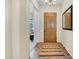 Inviting entryway with tile flooring, a wooden front door, and view into the adjacent bedroom at 42823 N Courage Trl, Anthem, AZ 85086