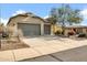 Charming home with a neutral color palette, three-car garage, a long driveway, and desert landscaping at 42823 N Courage Trl, Anthem, AZ 85086