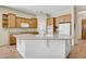 Well-equipped kitchen with a central island, light wood cabinetry, stainless-steel appliances, and tile floors at 42823 N Courage Trl, Anthem, AZ 85086