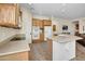 Well-equipped kitchen with a central island, light wood cabinetry, stainless-steel appliances, and tile floors at 42823 N Courage Trl, Anthem, AZ 85086