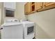 A laundry room with washer, dryer, and overhead cabinets for storage at 42823 N Courage Trl, Anthem, AZ 85086