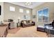 Cozy living room with bright windows and a comfortable sitting area, perfect for relaxation at 42823 N Courage Trl, Anthem, AZ 85086