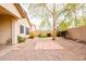 Backyard featuring desert landscaping with pavers, a tree, and a block wall at 45049 W Cypress Ln, Maricopa, AZ 85139