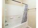 Clean bathroom showing a shower/tub combo with neutral tiles and a shower curtain at 45049 W Cypress Ln, Maricopa, AZ 85139