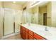 Bathroom with double sinks, walk in shower, large mirror, and tile flooring at 45049 W Cypress Ln, Maricopa, AZ 85139