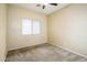Bedroom features neutral walls, carpeting, and a bright window with blinds at 45049 W Cypress Ln, Maricopa, AZ 85139
