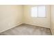 Neutral bedroom features soft carpeting and a window providing natural light at 45049 W Cypress Ln, Maricopa, AZ 85139