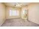 Bright, carpeted bedroom featuring large windows, neutral walls, and a comfortable layout for relaxation at 45049 W Cypress Ln, Maricopa, AZ 85139