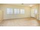 Bright living area features tile flooring, neutral paint, and multiple windows for ample natural light at 45049 W Cypress Ln, Maricopa, AZ 85139