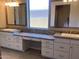 Bright bathroom featuring dual sinks, white cabinetry, and a central vanity area with granite countertops at 4593 W Agave Ave, Eloy, AZ 85131