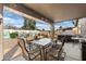 Relaxing back patio with tile table, a hot tub, and a decorative desert mural on the backyard wall at 48 E Nolana Pl, San Tan Valley, AZ 85143