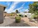 Serene backyard featuring a brick patio, lush greenery, desert-themed mural on the wall, and a tranquil outdoor space at 48 E Nolana Pl, San Tan Valley, AZ 85143
