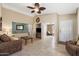 Spacious living room with neutral colors, ceiling fan, tile flooring, and access to additional rooms at 48 E Nolana Pl, San Tan Valley, AZ 85143