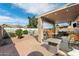 Inviting outdoor patio space with covered seating, pavers, and a vibrant painted mural fence at 48 E Nolana Pl, San Tan Valley, AZ 85143