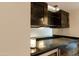 Modern bar area with dark cabinets, glass displays, and sleek black countertop at 4808 N 24Th St # 908, Phoenix, AZ 85016