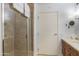 Bathroom featuring a tiled shower with a glass door and a wooden vanity with a round mirror at 4808 N 24Th St # 908, Phoenix, AZ 85016