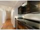 Hallway featuring hardwood floors adjacent to a bar with dark cabinets and black countertop at 4808 N 24Th St # 908, Phoenix, AZ 85016