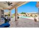 Relaxing covered back patio with ceiling fan, travertine pavers, and open view of the pool at 4944 E Dale Ln, Cave Creek, AZ 85331