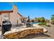 Charming backyard with flagstone patio, built-in BBQ, a pool, and mature desert landscape at 4944 E Dale Ln, Cave Creek, AZ 85331