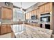 Modern kitchen boasts granite countertops, mosaic backsplash, stainless appliances, and ample cabinet space at 4944 E Dale Ln, Cave Creek, AZ 85331
