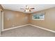 Bedroom with neutral carpet, tan walls, ceiling fan, and window with blue and white shade at 576 W Moon Valley Dr, Phoenix, AZ 85023