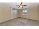 Spacious bedroom featuring carpeted floors, ceiling fan, and two windows offering plenty of natural light at 576 W Moon Valley Dr, Phoenix, AZ 85023