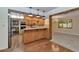 Open-concept kitchen featuring wood cabinetry, eat-in bar, and seamless connection to the dining area at 576 W Moon Valley Dr, Phoenix, AZ 85023