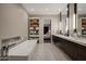 Spacious bathroom featuring a modern tub, vanity with dual sinks, and ample linen storage at 5935 N Echo Canyon Ln, Phoenix, AZ 85018