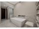 Modern bathroom with a freestanding tub, glass-enclosed shower, and stylish tile flooring at 5935 N Echo Canyon Ln, Phoenix, AZ 85018