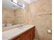 Bathroom featuring stone tile, wood cabinet, and ample counter space at 7131 E Rancho Vista Dr # 4003, Scottsdale, AZ 85251