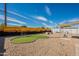 Large backyard with putting green, desert mural, and rock landscaping under a sunny blue sky at 829 W Mitchell Dr, Phoenix, AZ 85013