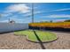 Backyard putting green surrounded by decorative rock, painted block wall, and blue sky at 829 W Mitchell Dr, Phoenix, AZ 85013