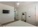 Minimalist bedroom with a ceiling fan, a wall-mounted TV and a full length mirror at 829 W Mitchell Dr, Phoenix, AZ 85013