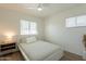 Bedroom with neutral tones, ceiling fan, bedside table and 2 windows at 829 W Mitchell Dr, Phoenix, AZ 85013