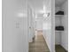 Bright hallway with wood floors and white walls leading to bedrooms and storage at 829 W Mitchell Dr, Phoenix, AZ 85013