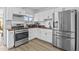 Well-lit kitchen featuring stainless steel appliances, white cabinetry, wood countertops, and a functional layout at 829 W Mitchell Dr, Phoenix, AZ 85013