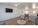 Open-concept living room with hardwood floors, a mounted TV, and seamless flow into the dining area at 829 W Mitchell Dr, Phoenix, AZ 85013