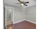 Bedroom with hardwood floors, ceiling fan, and a doorway to a bathroom at 8522 E Montebello Ave, Scottsdale, AZ 85250