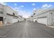 A street view showing a neat row of townhouses with attached garages, under a bright blue sky at 8614 N 67Th Dr, Peoria, AZ 85345