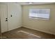 Bright bedroom with wood floors, a window and white door at 9019 W Griswold Rd, Peoria, AZ 85345