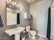 A well-lit bathroom featuring a white pedestal sink, toilet, and shower with curtain at 1 E Lexington Ave # 503, Phoenix, AZ 85012