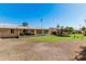 Expansive backyard featuring a large lawn area and covered patio at 10439 W Saratoga Cir, Sun City, AZ 85351