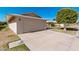 Beige home featuring a two-car garage and wide driveway at 10439 W Saratoga Cir, Sun City, AZ 85351