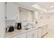 Bright kitchen featuring white cabinets, double sink, and modern appliances at 10439 W Saratoga Cir, Sun City, AZ 85351