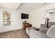 Cozy living room with wood-look flooring, mounted TV, and exterior access at 10439 W Saratoga Cir, Sun City, AZ 85351