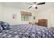 Bright bedroom featuring wood-look floors, ceiling fan, large bed, and side table at 10439 W Saratoga Cir, Sun City, AZ 85351