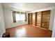 Bedroom with wood laminate floors, built-in shelving and a window at 10450 W Sutters Gold Ln, Sun City, AZ 85351