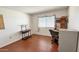 Bedroom with wood laminate floors, desk and a window at 10450 W Sutters Gold Ln, Sun City, AZ 85351