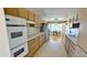 Traditional kitchen with wood cabinets, stainless steel appliances, and a dining area with abundant natural light at 10450 W Sutters Gold Ln, Sun City, AZ 85351